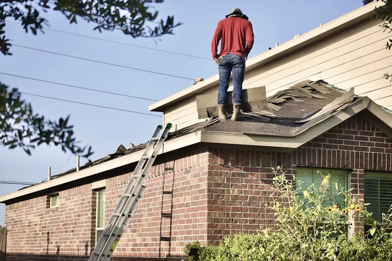 Professional roofer working on a residential roof in Parma